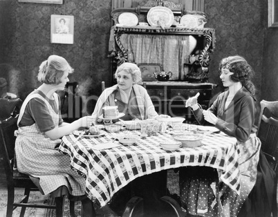 Three women sitting at the dining table talking