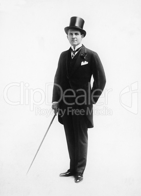 Portrait of a man in a top hat and morning suit holding a cane