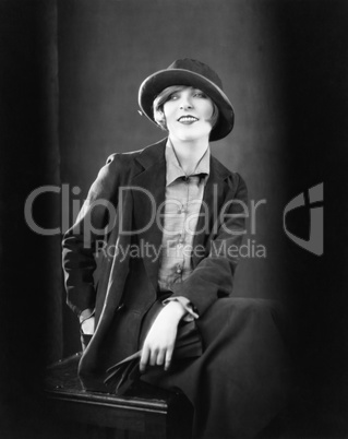 Portrait of a woman sitting on a stool and smiling