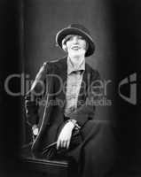 Portrait of a woman sitting on a stool and smiling