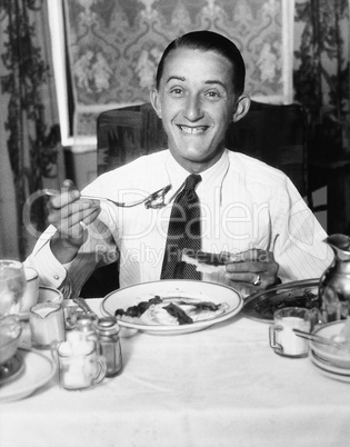 Young man having breakfast and smiling