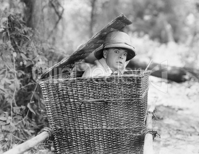 Man hiding himself in a basket