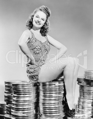 Portrait of a young woman sitting on stacks of film canisters