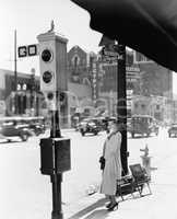 Profile of a young woman standing near a stop light