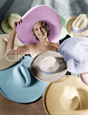 Portrait of a young woman covered with hats