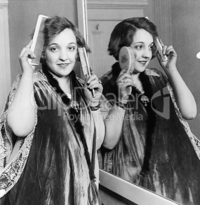 Woman combing and brushing her hair