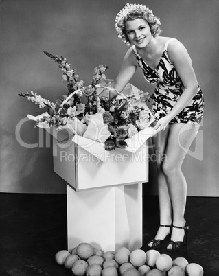 Portrait of a young woman opening a present and smiling