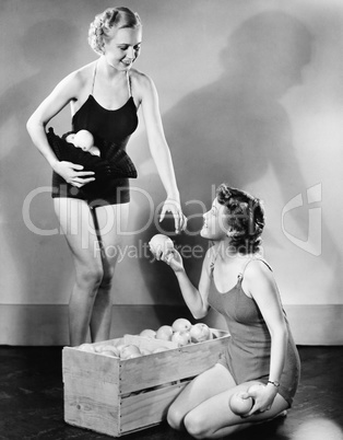 Profile of a young woman giving fruits to her friend