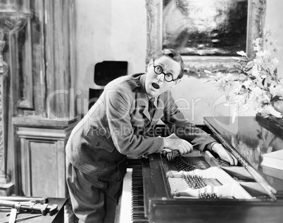 Man shouting with his hand caught in a piano