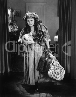 Young woman carrying a luggage and a pig