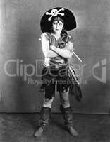 Female in a pirate's costume standing with her arms crossed and holding a knife