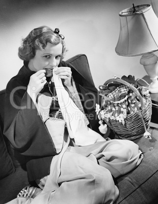 Portrait of a young woman cutting thread with her teeth