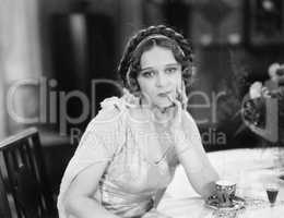 Portrait of a young woman sitting at a table and thinking in a restaurant