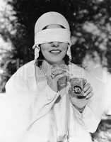 Young woman with blindfolded eyes taking out a cigarette from a cigarette pack