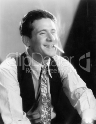 Young man laughing and smoking a cigarette