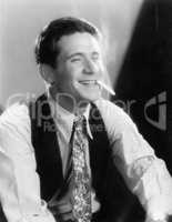 Young man laughing and smoking a cigarette