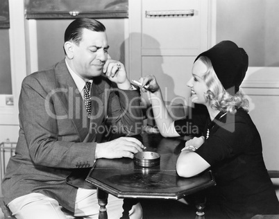 Profile of a man with a young woman smoking sitting in a cafe