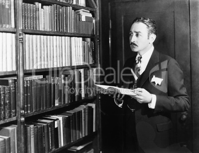 Man selecting books from bookshelf in a library