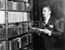 Man selecting books from bookshelf in a library