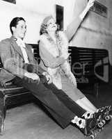 Couple wearing roller skates and sitting on a bench
