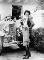 Portrait of a woman in front of her car in a riding outfit