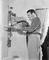 Profile of a man cleaning a cage with a vacuum cleaner