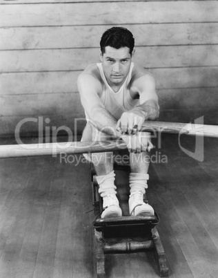 Portrait of a young man exercising on a rowing machine