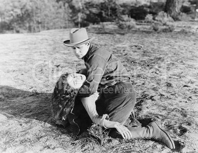 Young man holding an unconscious young woman