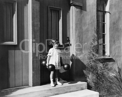 Girl holding dumbbells and standing in front of a door