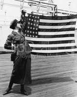 Young woman in military uniform holding up an American flag