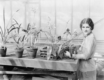 Portrait of a young woman attending to her orchids