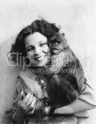 Portrait of a young woman hugging her monkey