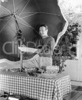 Man standing at a picnic table and holding a plate