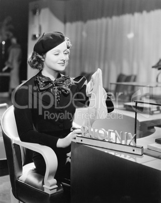 Young woman sitting in a department store and holding stockings
