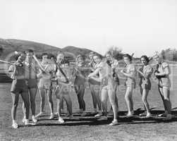 Group of women holding baseball bats and standing in a row