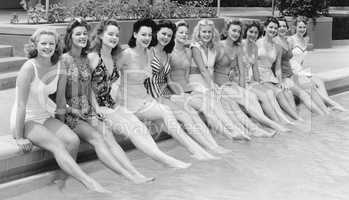 Group of women sitting in a row at the pool side