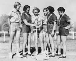 Woman holding a baseball bat and giving training to other women