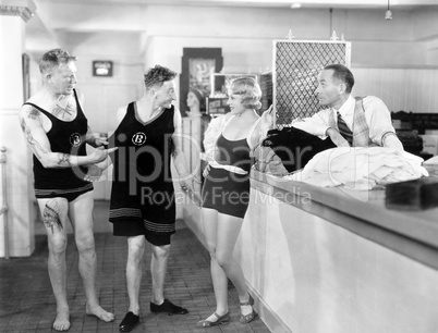 Man trying on an oversized shirt in a store with his friends