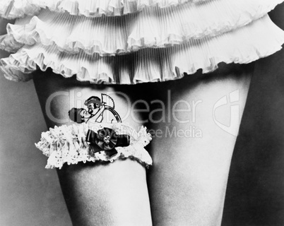 View of a woman hiding a tattoo with a garter on her thighs
