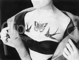 Close-up of a woman showing tattoos on her chest