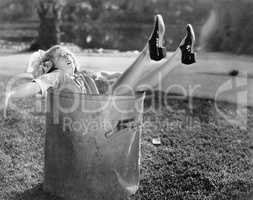 Woman fallen in the garbage bin at the roadside