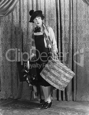 Woman in a beret holding a hat box and presents