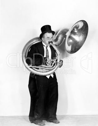 Man playing a tuba in a top hat
