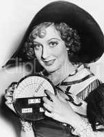 Portrait of a young woman in a hat holding a newly invented speedometer