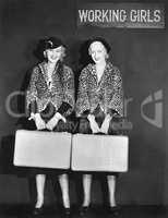 Portrait of two air hostess holding suitcases and smiling