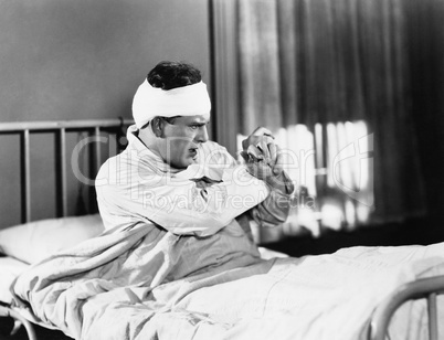 Man sitting on a hospital bed looking feared