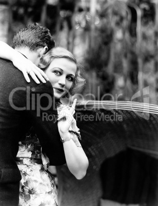 Young woman embracing a man and pointing towards an information board