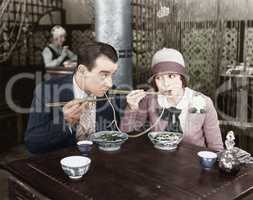 Couple sharing a noodle in a restaurant