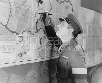 Soldier looking at a map marking it with a pen