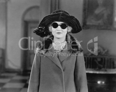 Portrait of woman in hat, sunglasses and coat